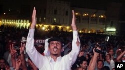 File - Qataris react in the streets, after the announcement that Qatar will host the soccer World Cup in 2022, in Doha, Dec. 2, 2010.