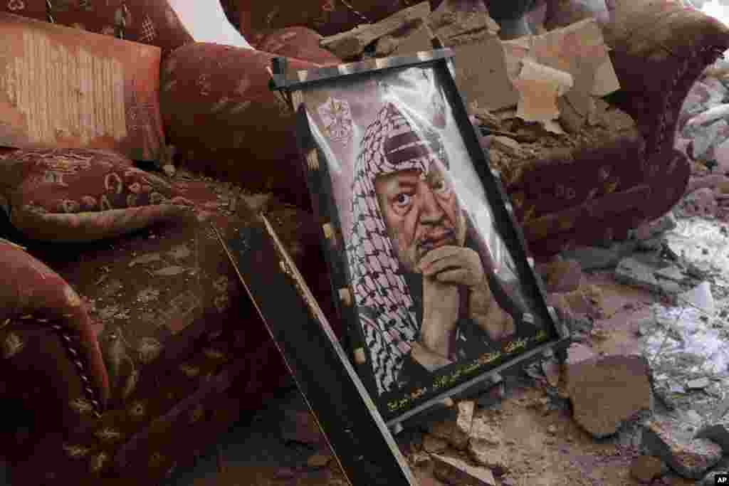 A poster of later Palestinian leader Yasser Arafat is seen on the rubble of a destroyed house in the Bureij refugee camp in the central Gaza Strip, Aug. 1, 2014.