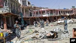 Tentara Afghanistan berjalan di tengah puing-puing setelah terjadi serangan bom bunuh diri Taliban di Ghazni, Afghanistan (4/9/2014). 