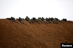 Israeli soldiers are seen next to the border fence on the Israeli side of the border with the northern Gaza Strip, Israel.