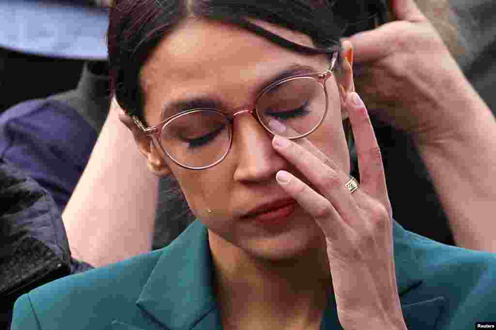 American lawmaker Alexandria Ocasio-Cortez (D-NY) wipes tears as her fellow Congresswoman Ilhan Omar (D-MN) talks about her experience as a refugee during a news conference to call on Congress to cut funding for ICE (Immigration and Customs Enforcement), at the U.S. Capitol in Washington, D.C.