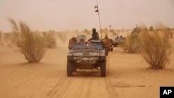 Pasukan Perancis berpatroli di gurun yang berbatasan dengan Niger di pinggiran Asongo, Mali utara (24/6). (AP/Maeva Bambuck)