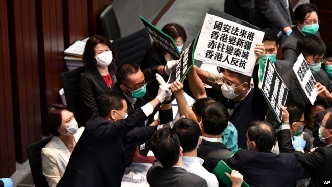 香港立法会泛民主派议员在内务委员会的一个会议期间举牌抗议中国人大制定香港国安法,他们被保安阻拦。(2020年5月22日)