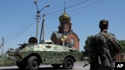 Pemberontak pro-Rusia berdiri di pos pemeriksaan di desa Karlivka dekat Donetsk, Ukraina timur (1/7). (AP/Dmitry Lovetsky)