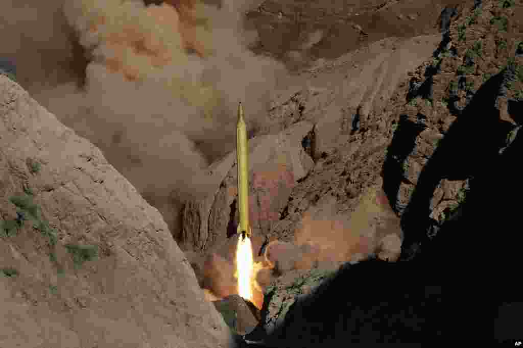 In this photo obtained from the Iranian Fars News Agency, a Qadr H long-range ballistic surface-to-surface missile is fired by Iran&#39;s Revolutionary Guard, during a maneuver, in an undisclosed location.