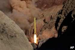 In this photo obtained from the Iranian Fars News Agency, a Qadr H long-range ballistic surface-to-surface missile is fired by Iran's Revolutionary Guard, during a maneuver, in an undisclosed location in Iran, Wednesday, March 9, 2016.