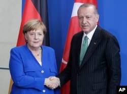 레제프 타이이프 에르도안 터키 대통령(오른쪽)과 앙겔라 메르켈 독일 총리가 독일 베를린에서 공동기자회견을 한 후 악수하고 있다.