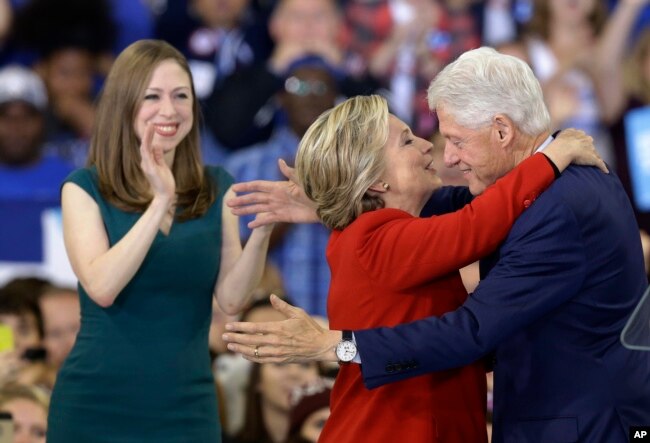 FILE - Democratic presidential candidate Hillary Clinton hugs her husband, former President Bill Clinton as their daughter Chelsea Clinton looks on during a campaign rally in Raleigh, N.C., Nov. 8, 2016. (AP Photo/Gerry Broome)