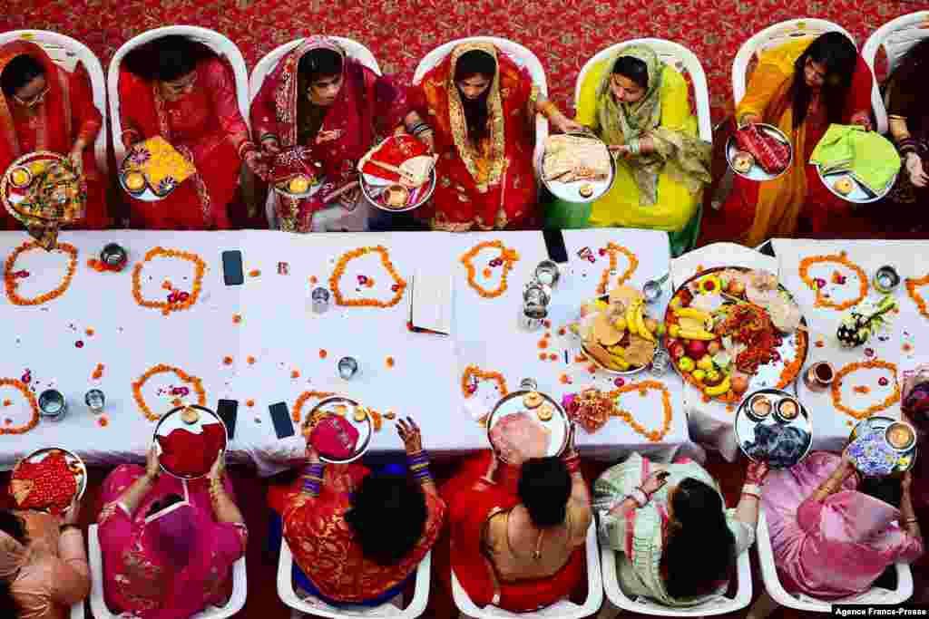 Hindu married women offer prayers during celebrations of the Karva Chauth festival, in which married women fast the whole day and offer prayers to the moon for the welfare, prosperity, and longevity of their husbands in Allahabad, India.