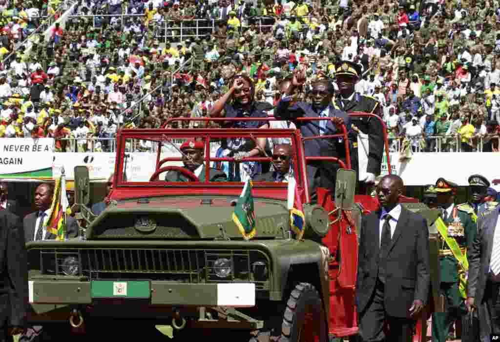 Zimbabwean President Robert Mugabe and his wife Grace greet the crowd as they arrive for his inauguration in Harare, August 22, 2013.