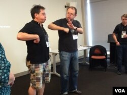 Stephen Moschner demonstrates the secret to circular breathing by having workshop participants imagine playing the bagpipe. (Gail Wein/VOA)