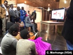People follow Zimbabwe Electoral Commission announcement of the July 30, polls at a hotel in Harare, Zimbabwe, Aug. 2, 2018.