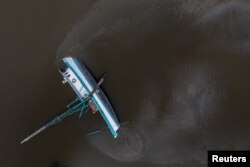 Bahan bakar bocor dari kapal terbalik di sepanjang Bayou Lafourche akibat hantaman Badai Ida di Galliano, Louisiana, AS, 31 Agustus 2021.