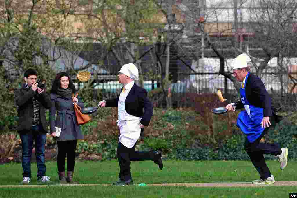 British parliamentarians Lord St John of Bletso (R) and Julian Huppert MP (2nd R) take part in the annual pancake race on Shrove in central London.