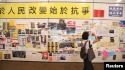 一名女子在香港地鐵東涌站的連儂牆前拍照。（2019年8月24日） 