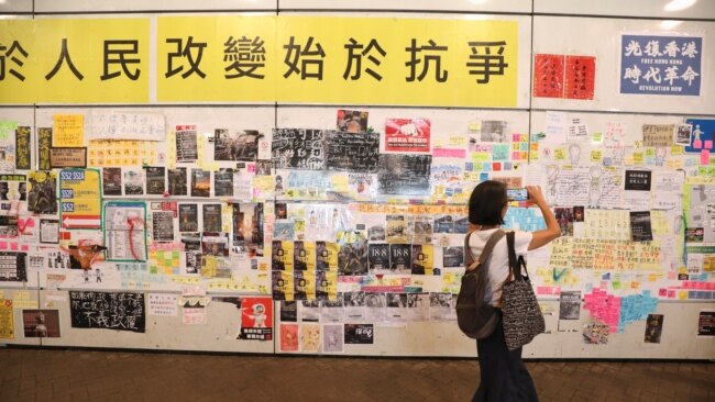 一名女子在香港地铁东涌站的连侬墙前拍照。(2019年8月24日)