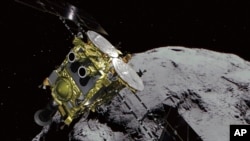 This computer graphics image provided by the Japan Aerospace Exploration Agency (JAXA) shows an asteroid and asteroid explorer Hayabusa2. The Japanese unmanned spacecraft Hayabusa2 released two small Minerva-II-1 rovers on the asteroid Ryugu on Friday, Sept. 21, 2018 (JAXA via AP).