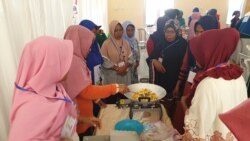 Para perempuan mempraktikkan cara membuat camilan kacang sembunyi dalam kegiatan pelatihan keterampilan di Petobo, Kota Palu, Sulawesi Tengah, Rabu, 18 September 2019. (Foto: Yoanes Litha/VOA)