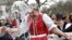 Men throw water on a woman as part of traditional Easter celebrations in Szenna, Hungary, March 28, 2016. 