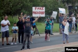 A protester stands by the motorcade transporting U.S. President Donald Trump to a briefing on Tropical Storm Harvey relief efforts at the Texas Department of Public Safety Emergency Operations Center in Austin, Texas, Aug. 29, 2017.