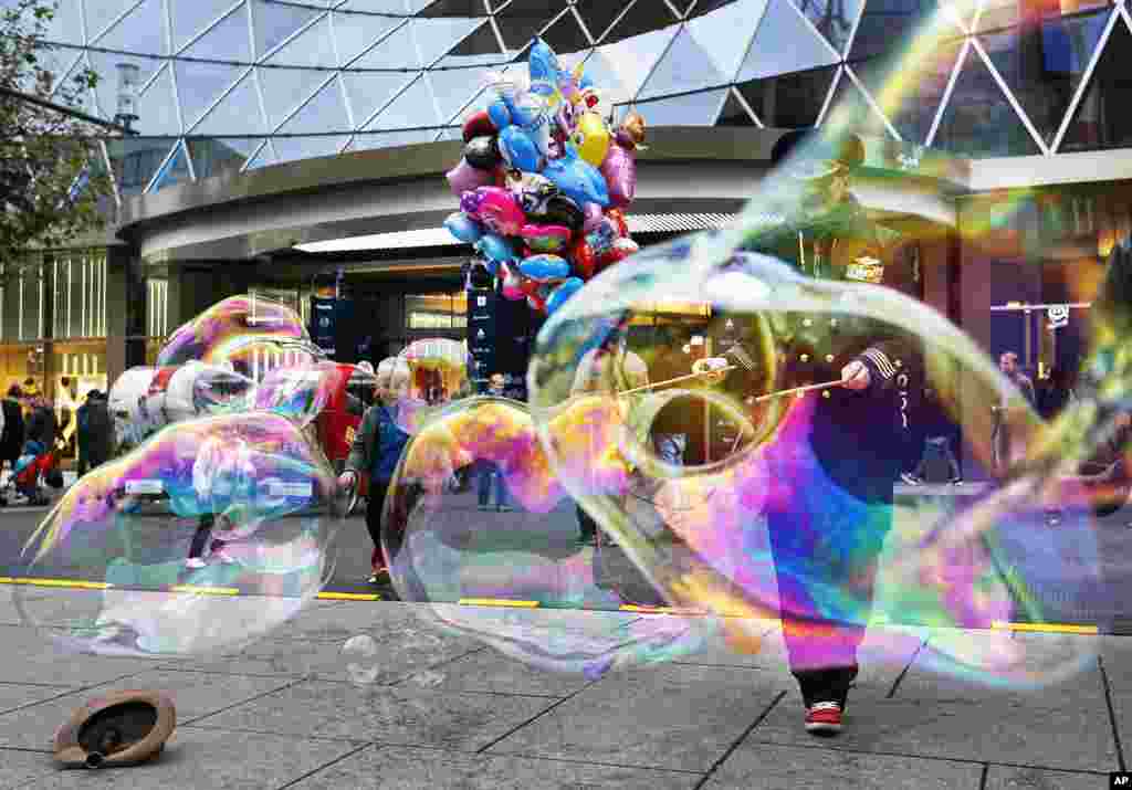 A woman creates bubbles in the main shopping street in Frankfurt, Germany.