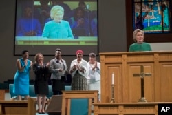 Democratic presidential candidate Hillary Clinton is joined by mothers of black men who died from gun violence, as she speaks during Sunday service at Union Baptist church, Sunday, Oct. 23, 2016, in Durham, N.C.