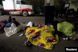 Migrants from Honduras, part of a new caravan from Central America trying to reach the United States, sleep on the ground at the Agua Caliente border checkpoint, in Esquipulas, Guatemala, Jan. 16, 2019.
