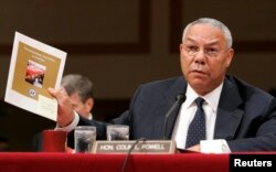 FILE - U.S. Secretary of State Colin Powell holds up a State Department report documenting atrocities in Darfur while testifying before the Senate Foreign Relations Committee on Capitol Hill in Washington, September 9, 2004.