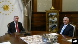 Turkey's President Recep Tayyip Erdogan, left, meets with Turkey's Prime Minister Bibali Yildirim, right, in Ankara, July 19, 2017. (Presidency Press Service via AP, Pool)