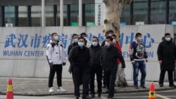Plainclothes security personnel stand outside the Wuhan Center for Disease Control and Prevention before the World Health Organization team arrive to make a field visit in Wuhan in central China's Hubei province on Monday, Feb. 1, 2021. (AP Photo/Ng Han G