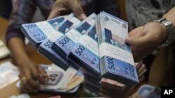 Seorang petugas sedang menghitung jumlah uang rupiah di kantor penukaran mata uang asing di Jakarta (Foto: dok). 