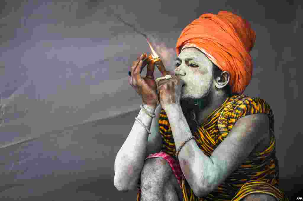 An Indian sadhu (Hindu holy man) smokes inside his tent among the Juna Akhara (a sadhu order) community at the Kumbh Mela festival in Allahabad.