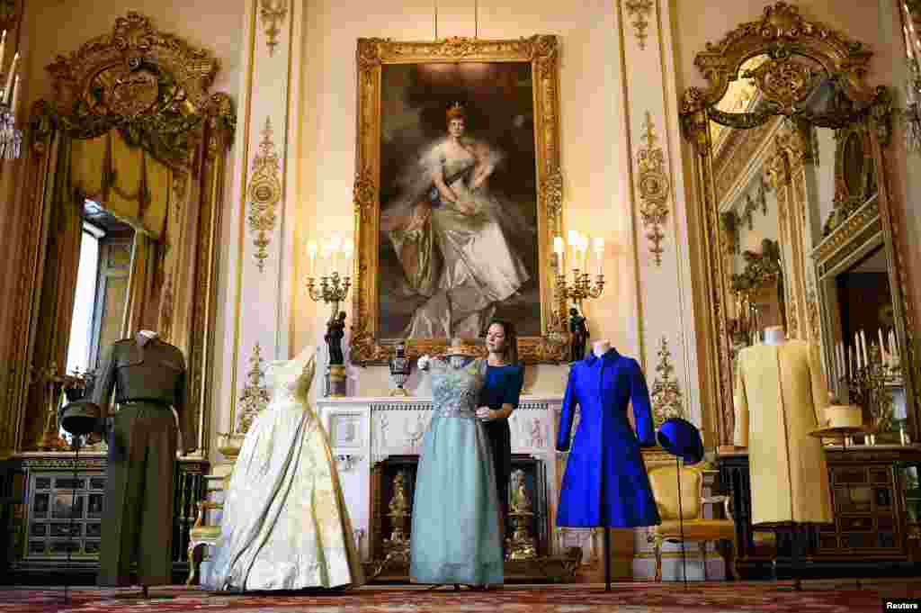 전시기획자 캐롤라인 드 기토가 &#39;여왕의 옷장-90년에 걸친 스타일&#39;이라는 제목의 전시회에 내놓을 작품들을 준비하고 있다. 영국 런던의 버킹엄 궁전에서 열리는 이 행사에는 엘리자베스 여왕의 공식&middot; 비공식 의복이 상당수 전시된다. &nbsp;