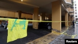 A Hezbollah flag is seen near the crime scene where commander Hasan al-Laqqis was killed in the southern Hadath district in Beirut, Dec. 4, 2013.