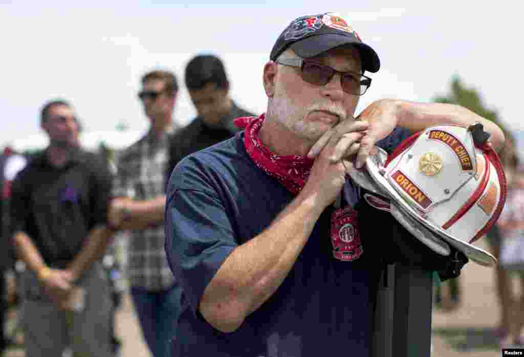 Retired Moline, Illinois firefighter Mike Radford watches a memorial service for Prescott&#39;s Granite Mountain Hotshots on a screen from a parking lot outside Tim&#39;s Toyota Center, July 9, 2013 in Prescott, Arizona.&nbsp;