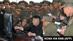 Lãnh tụ Bắc Triều Tiên Kim Jong-Un xem một cuộc tập trận pháo kích của đơn vị pháo binh trên máy tính cùng các giới chức quân đội (Ảnh tư liệu do thông tấn xã Bắc Triều Tiên KCNA phát hành).