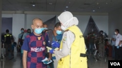 Tenaga kerja Indonesia (TKI) saat tiba di Bandara Internasional Kualanamu, Deli Serdang, Sumatera Utara, Kamis 9 April 2020. (Foto: VOA/Anugrah Andriansyah)