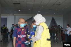 Tenaga kerja Indonesia (TKI) saat tiba di Bandara Internasional Kualanamu, Deli Serdang, Sumatera Utara, Kamis 9 April 2020. (Foto: VOA/Anugrah Andriansyah)