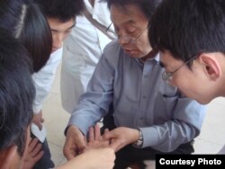 A patient is examined for signs of arsenic poisoning, seen here as hyperkeratosis or a thickening of the skin’s outer layer. (Prof. Guifan Sun, China Medical University, Shenyang)