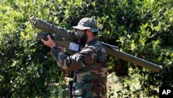 FILE - A Hezbollah fighter holds an Iranian-made anti-aircraft missile on the border with Israel, in Naqoura, south Lebanon, April 20, 2017. The British government will make inciting support for Hezbollah a criminal offense.