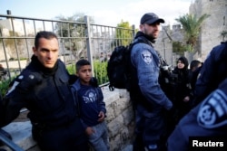 A Palestinian youth stands next to an Israeli policeman after being detained during a protest following U.S. President Donald Trump's announcement that he has recognized Jerusalem as Israel's capital, near Damascus Gate in Jerusalem's Old City, Dec. 7, 2017.