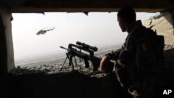 A soldier from the French Foreign Legion, a unit of the French army, keeps watch as a military helicopter flies at a base in Kabul, Afghanistan, Oct. 2009. (file photo)