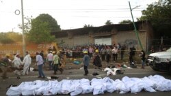 Los cuerpos en bolsas para cadáveres se colocan a un costado de la carretera después de un accidente en Tuxtla Gutiérrez, estado de Chiapas, México, el jueves 9 de diciembre de 2021.