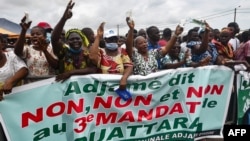 Les gens applaudissent derrière une banderole "Adjame dit non, non et non, à un 3e mandat de Ouattara", le 26 septembre 2020, à Yopougon, Abidjan.