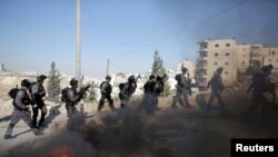 Polisi perbatasan Israel berlari dekat ban yang dibakar dalam bentrokan dengan warga Palestina karena insiden pada hari Rabu di Issawiya, Yerusalem timur, 24 Oktober 2014.