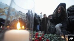 People lay flowers as they attend a rally to commemorate the victims of last month's deadly suicide bombing at Moscow's Domodedovo airport, January 27, 2011