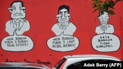 Sebuah mural bertuliskan "Saya Bangga Punya Tiga Rumah Mewah (Kiri), Saya Bangga Punya Lima Mobil Mewah (C), Saya Bangga Tidak Melakukan Korupsi", di dinding sebuah jalan di Jakarta pada tanggal 18 November 2009 .(Foto: AFP/Adek Berry)