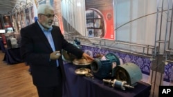 Deputy head of the Atomic Energy Organization of Iran Asghar Zarean explains about a part of a machine of the country's nuclear facilities in Tehran, Iran, Sept. 1, 2014. 