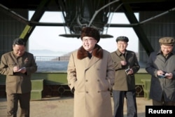 FILE - North Korea leader Kim Jong Un smiles as he visits Sohae Space Center in Cholsan County, North Pyongan province for the testing of a new engine for an intercontinental ballistic missile in this undated photo.