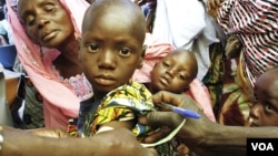 A health worker in Mali checks a child's nutritional status by measuring the upper arm, March 2012. (N. Palus/VOA)